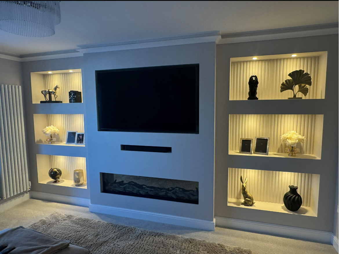 Bespoke media wall with recessed TV, electric fireplace, and LED-lit display shelving